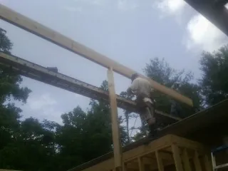Carpenter setting a ridge beam over a new addition frame — Ice Dam Removal by Roofing Brothers in Selkirk