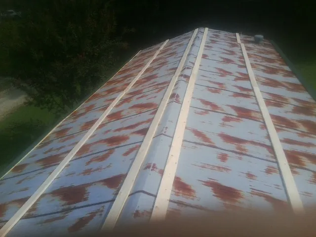 Rusted metal roof panels with new wood purlins before replacement — Storm Damage Roof Repair in Selkirk by Roofing Brothers