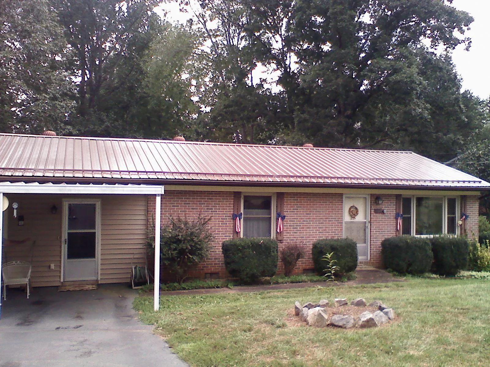 Bronze metal roof and carport on a brick ranch home — Roof Repair work by our crew in Selkirk